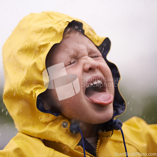 Image of Child, nature and rain with jacket for freedom, fun and carefree enjoyment in Australia. Droplets, kid and face with tongue out for vacation, weekend or holiday in winter with water protection