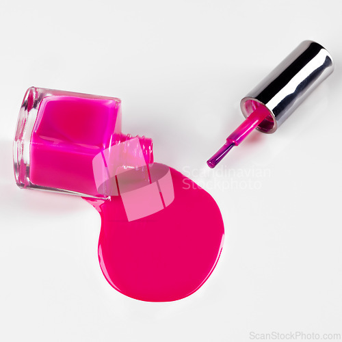 Image of Nail polish, bottle spill and pink on a white background for beauty, cosmetics and salon products. Cosmetology, spa and isolated liquid, drip and paint for manicure, pedicure and pamper in studio