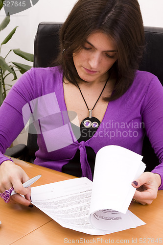 Image of businesswoman signing documents