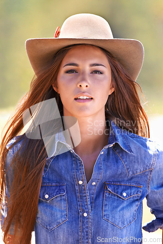 Image of Cowgirl, portrait and hat at farm, field and western fashion for agriculture, work and outdoor in summer. Woman, person and farmer at ranch for sustainability, countryside and environment in Texas