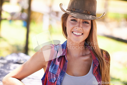 Image of Cowgirl, portrait and hat at farm, happy and western fashion for agriculture, field and nature in summer. Woman, person and farmer at ranch for sustainability, countryside and environment in Texas