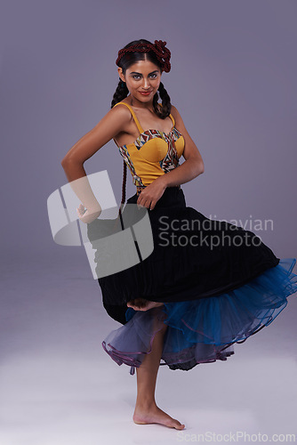 Image of Dancer, studio or woman in dress dancing with energy, freedom or fashion in portrait for style. Spanish, purple background or artist in flamenco, tango or performance in musical culture or tradition