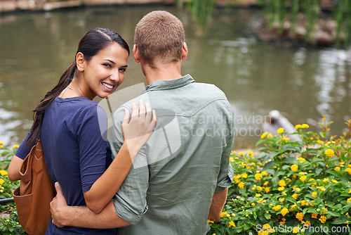 Image of Couple, hug and love or portrait at park, relationship and care on outdoor adventure or holiday. People, happy and embrace on vacation and romance at sanctuary, zoo and calm or peace on weekend trip
