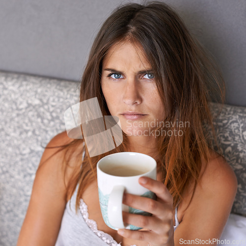 Image of Angry, woman and portrait with coffee in bed, frustrated and warm beverage for mental health in home. Lady, face and upset in bedroom with espresso cup and morning energy for burnout in apartment