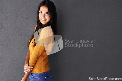 Image of Mockup space, fashion and female model in studio, portrait and cool or trendy style in gray background. Woman, smile and happy with confidence or pride, stylish or edgy in casual outfit or clothes
