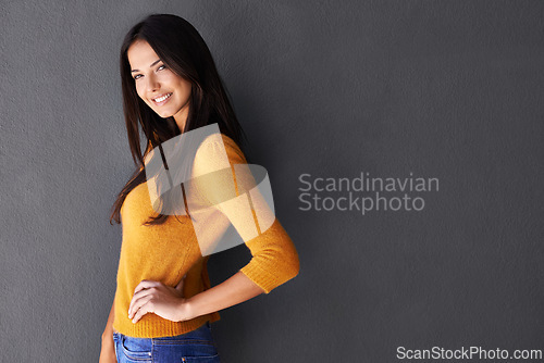 Image of Portrait, trendy and female model in studio, fashion and cool style in gray background. Woman, smile and happy with confidence or pride in mockup space, stylish and edgy in casual outfit or clothes