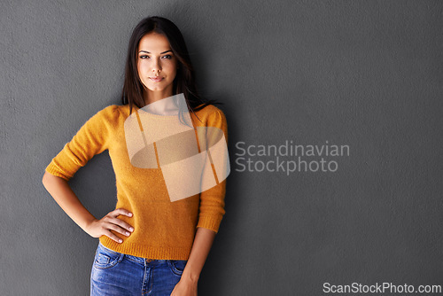 Image of Portrait, fashion and woman in studio, edgy and cool or trendy style in gray background. Female model, proud and confidence or pride in mockup space, standing and stylish in casual outfit or clothes