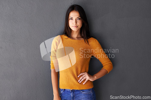 Image of Portrait, fashion and female model in studio, cool and edgy or trendy style in gray background. Woman or person and proud with confidence or pride, standing and stylish in casual outfit or clothes