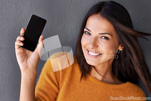 Image of Woman, portrait and phone screen in studio, blank and mockup space for website or app. Female person, breeze and empty display for marketing or advertising, social media and online by gray background