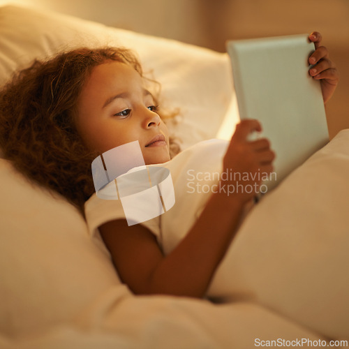 Image of Bedtime, child and tablet in bed at night, comfortable and online for games or play in home. Female person, girl and rest in bedroom or closeup to relax, website and internet or app for entertainment