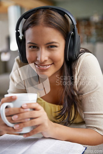 Image of Music, coffee and woman relax with a book on sofa in home on holiday, reading with a drink and happiness. Girl, smile and hearing sound from headphones on couch with free audio, novel and enjoy tea