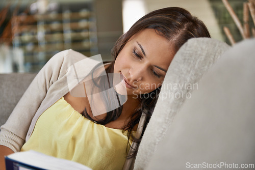 Image of Woman, reading and relax on couch with a book on holiday or vacation in home with study of philosophy or language. Calm, break and learning about history from novel on comfortable sofa in apartment
