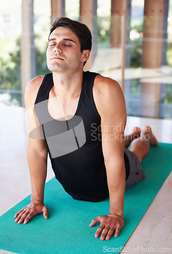 Image of Exercise, stretching and man during yoga, fitness and workout at wellness center. Flexible, relax and mindset or wellbeing and breath work, health or pilates mat for outdoor meditation in cobra pose