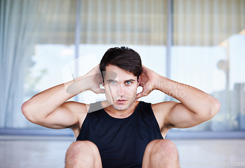 Image of Man, portrait and sit ups for fitness, core training for body and self care in apartment. Serious athlete, exercise and endurance in workout for health, wellness for sports and challenge at home