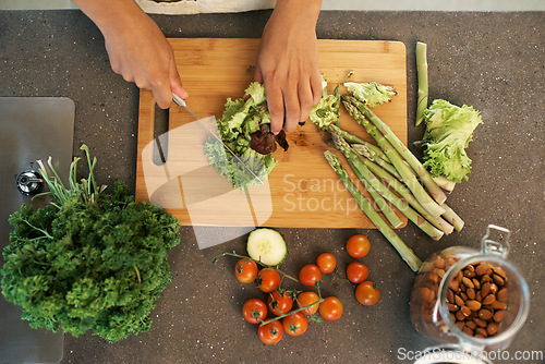 Image of Hands, knife and above for vegetables in kitchen with chopping, asparagus and cooking with nutrition for dinner. Chef, person and meal prep with vegan diet for food, wellness and lunch in apartment