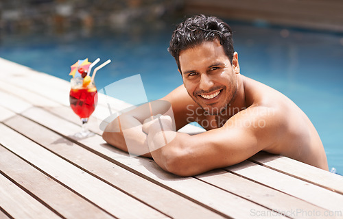 Image of Man, relax and portrait at swimming pool with cocktail at hotel, resort and travel on luxury vacation. Summer, holiday and glass of alcohol to drink with happiness on deck at poolside in Miami