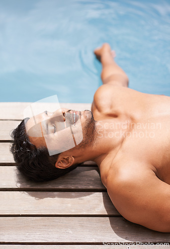 Image of Pool, deck and man relax in summer with happiness at hotel, resort or peace at villa in Miami for vacation. Calm, holiday and person lying at water in sunshine at poolside with smile in Florida