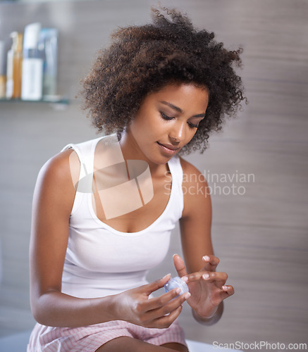 Image of African woman, cream and container in morning, skincare or start routine in bathroom at apartment. Girl, person and serum for change, cosmetics or benefits for facial skin with transformation in home