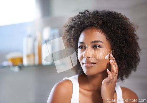 Image of Black woman, cream on face and skincare in bathroom for beauty at home, morning routine and antiaging treatment. Facial, mask with lotion or sunscreen, cosmetic care and moisturizing for healthy skin