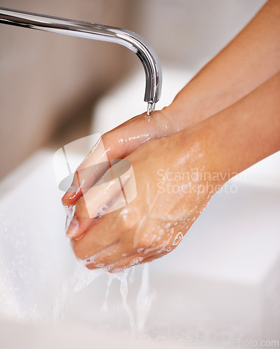 Image of Hands, water and soap for person cleaning in skincare, routine and grooming in home closeup. Bathroom, tap and washing skin with foam for sanitary protection of hygiene from germs, bacteria and virus