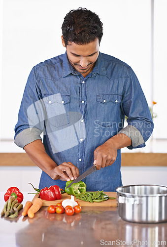 Image of Cooking, man and cutting vegetables on kitchen counter for healthy diet, nutrition or lunch. Chopping board, food and vegan person preparing salad for dinner, meal and organic ingredients in home