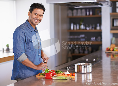 Image of Cooking, portrait and happy man chopping vegetables on kitchen counter for healthy diet, nutrition or lunch. Cutting knife, food and face of person preparing fresh salad for organic meal in home