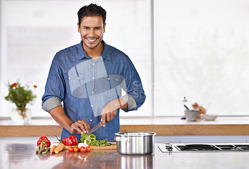 Image of Cooking, portrait and happy man cutting vegetables on kitchen counter for healthy diet, nutrition or lunch. Chopping board, food and face of person preparing fresh salad for organic meal prep in home