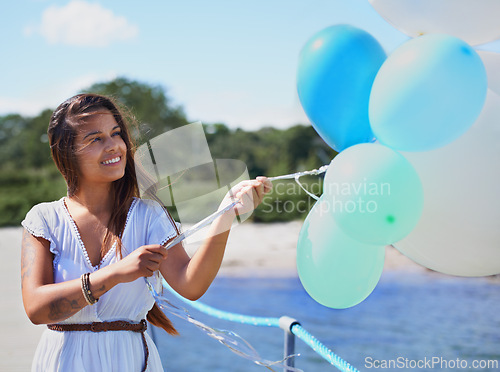 Image of Woman, happy and hold balloons on beach for freedom on holiday season or travel, relax and carefree with joy. Female person, outdoors and helium for celebration or birthday on summer vacation.