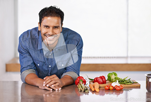 Image of Man, smile and vegetables in kitchen for food, cooking and recipe for health indoor on mockup. Nutritionist or vegan with carrot, pepper and tomatoes with garlic for ingredient and vitamin