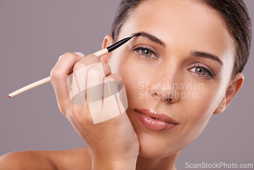 Image of Woman, beauty and eyebrow brush with makeup, portrait and studio for glamour and radiance and lip gloss. Female person, blush and foundation in grey background, sexy and attractive confidence