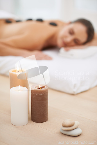 Image of Relax, candles and woman with hot stone massage at spa for health, wellness or luxury holistic treatment. Self care, peace and girl with natural body therapy, comfort and calm pamper service at hotel