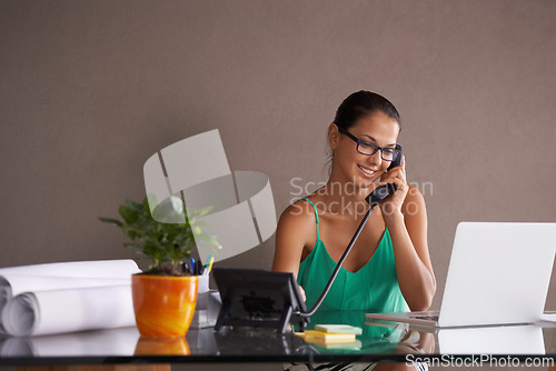 Image of Phone call, remote work and landline with receptionist woman in office for communication or reception. Laptop, smile and happy young woman answering telephone in small business or startup workplace