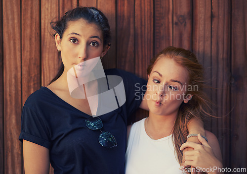 Image of Portrait, funny face and best friends on wooden background together for bonding or relationship. Love, goofy or silly and happy young women having fun with fashion in summer for holiday and vacation