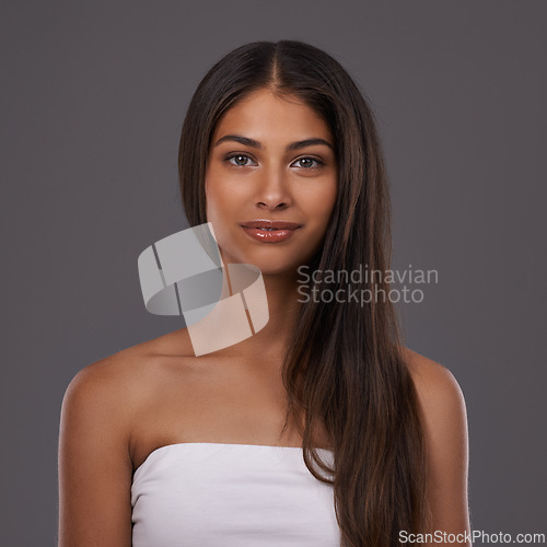 Image of Hair care, portrait and woman with beauty, skincare or shine isolated on a gray studio background. Hairstyle, cosmetics or face of Indian model in makeup at salon for treatment or glow at hairdresser
