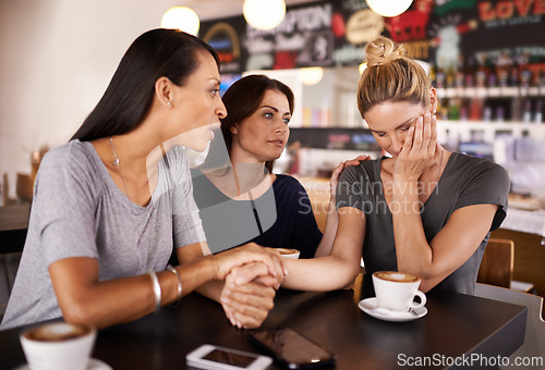 Image of Friends, coffee and sad woman in cafe for support in mental health, counselling and help for stress. Restaurant, trust and group of women holding hands or talking for comfort, empathy or bad news