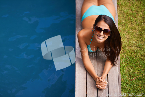 Image of Portrait of woman, bikini or tanning at swimming pool to relax or chill in summer holiday vacation in Hawaii. Smile, break or happy person sunbathing in swimwear at resort, home or hotel for peace