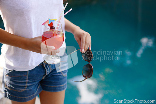 Image of Person, hands and cocktail at pool in summer on holiday or vacation with luxury hospitality at hotel. Alcohol, drink and guest relax outdoor at villa with fashion, style and sunglasses by water