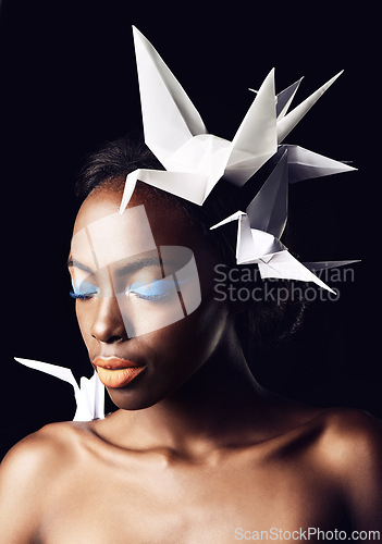 Image of Black woman, fine art and blue eyeshadow with beauty, dove or origami birds on a dark studio background. Closeup or face of African female person or model with makeup or cosmetics on mockup space