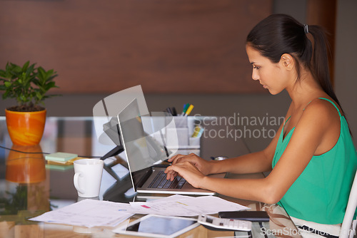 Image of Business woman, reading and planning on laptop for financial research, email or internet in her office. Young worker or professional accountant with computer for budget report, typing and information