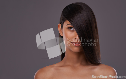 Image of Woman, studio and haircare with thinking beauty, Indian female person with luxury and salon treatment. Brazilian and keratin blowout for results and wellness, confident and isolated glowing model