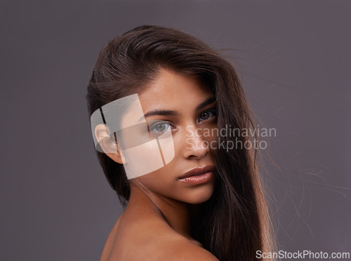 Image of Portrait, hair care or skincare of woman in makeup, glow or shine isolated on gray studio background. Face, hairstyle or serious Indian model in cosmetics at salon for beauty treatment at hairdresser