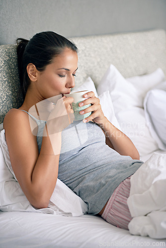 Image of Woman, drinking coffee and bed for morning caffeine on weekend or relaxing break, day off or leisure. Female person, beverage and linen in apartment with for Sunday holiday or peace, resting or calm