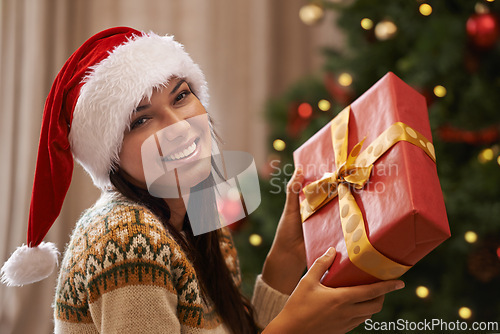 Image of Christmas, smile and portrait of woman with present at her home for festive celebration, event or party. Excited, happy and female person with gift box for xmas surprise in living room at apartment.