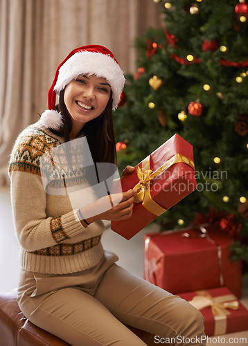 Image of Christmas, confident and portrait of woman with present at her home for festive celebration, event or party. Smile, happy and female person with gift box for xmas surprise in living room at apartment