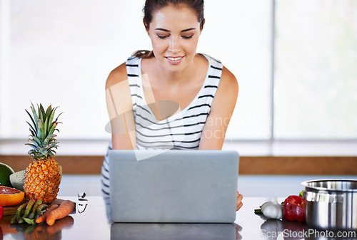 Image of Woman, thinking and laptop on kitchen counter, happy female person and home on internet. Google it, browsing cooking recipes and social media, online search on technology for healthy food ideas