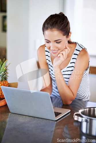 Image of Woman, working and laptop on kitchen counter, happy female person and home on internet. Google it, browsing cooking recipes and social media, online search on technology for healthy food ideas