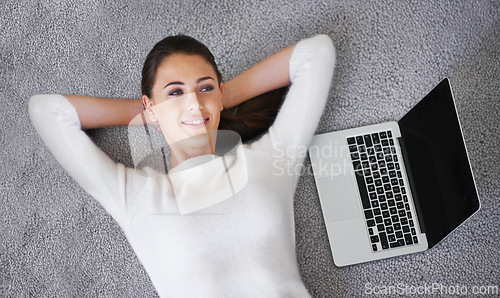 Image of Happy woman, relax and lying with laptop on floor for break, rest or research above at home. Top view of female person or freelancer with smile, computer or thinking on rug and mockup screen at house