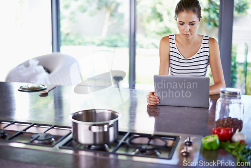 Image of Woman, kitchen and laptop for food idea, female person and home on internet. Google it, browsing cooking recipes and social media, online search with technology or thinking of healthy meal to prepare