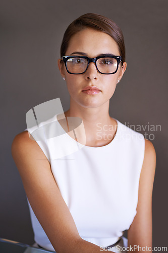 Image of Woman, serious and portrait in glasses with frame in studio and trendy eyewear for optometry. Consultant, confident or face for work in spectacles, vision or prescription eyecare by brown background