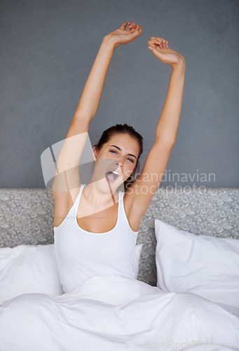 Image of Woman, stretching and wake up in bed with yawn in morning with fatigue after resting. Tired, girl and sitting in bedroom with exhausted energy and relax on holiday or vacation in hotel or home